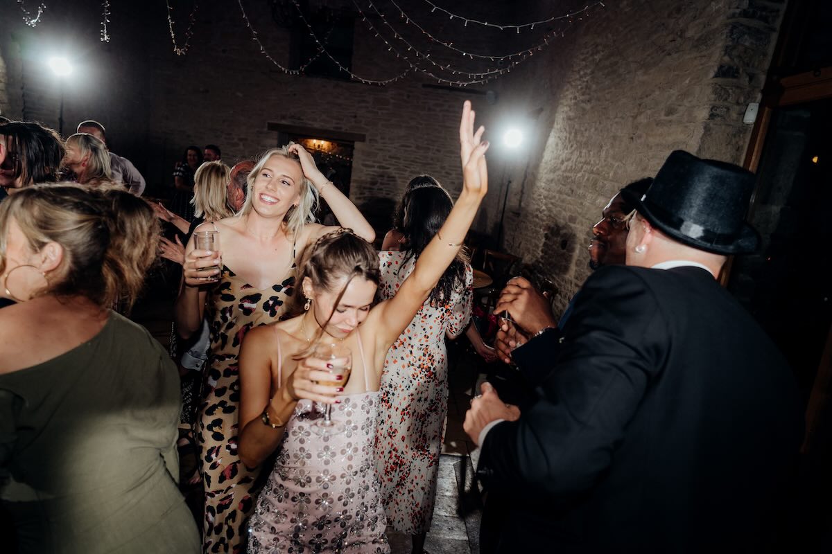 Wedding guests dancing at a barn wedding DJ set